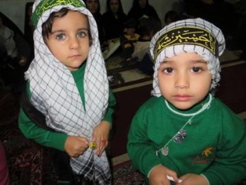 Two children in green outfits with head coverings. image link to story