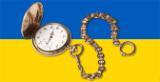 Gold pocket watch with a white face and roman numerals on a Ukranian flag background
