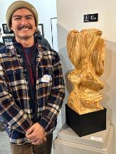 Mako Watanabe standing next to his award-winning sculpture at the 3rd Annual Juried Show at Combine Art Collective in Walla Walla, Washington
