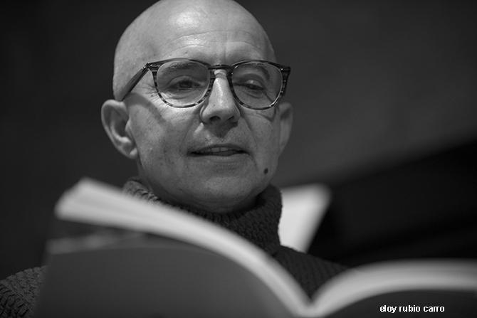 Juan Velasco holding an open book.