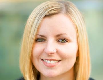 A person smiling with a blurred background. image link to story