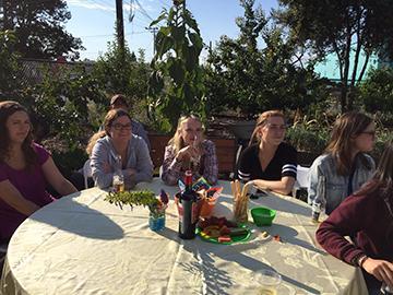 A group of people seated at a round table outdoors.