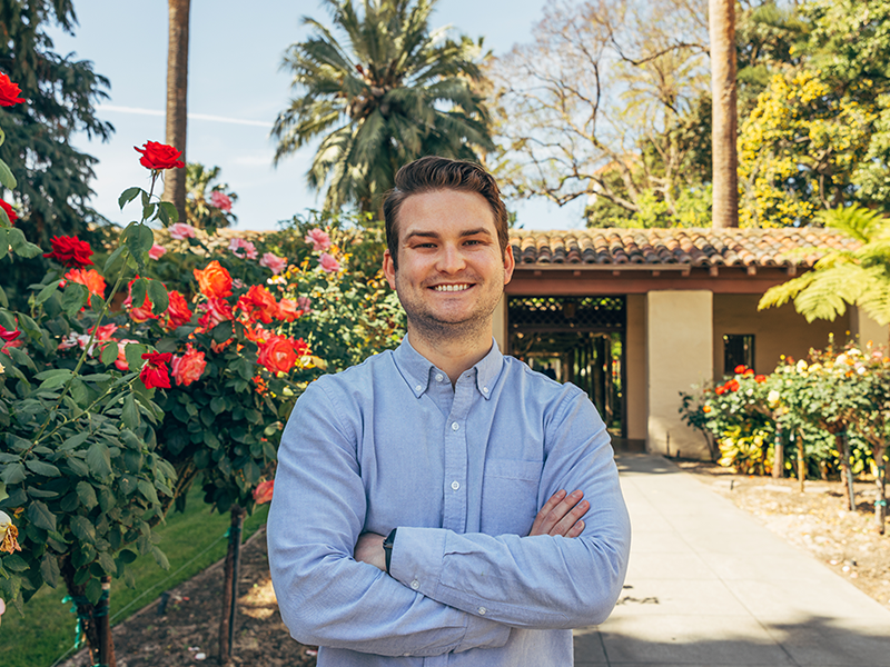 Henry Furguson standing next to rose bushes. image link to story