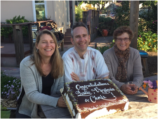 Three people posing with a cake that says Congratulations Tura and Danny.
