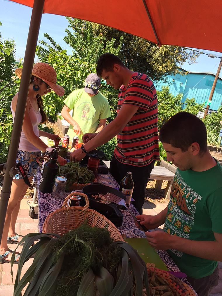 Two people gardening under an orange umbrella on Earth Day. image link to story