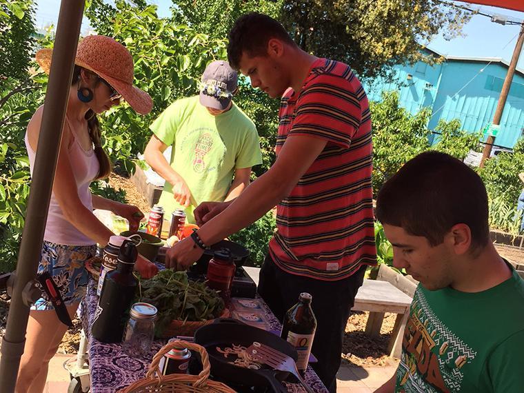 Two people gardening under an orange umbrella on Earth Day. image link to story
