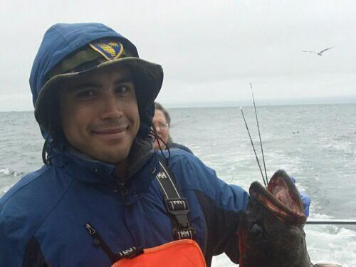 Person holding a fish on a boat while wearing orange and blue clothing. image link to story