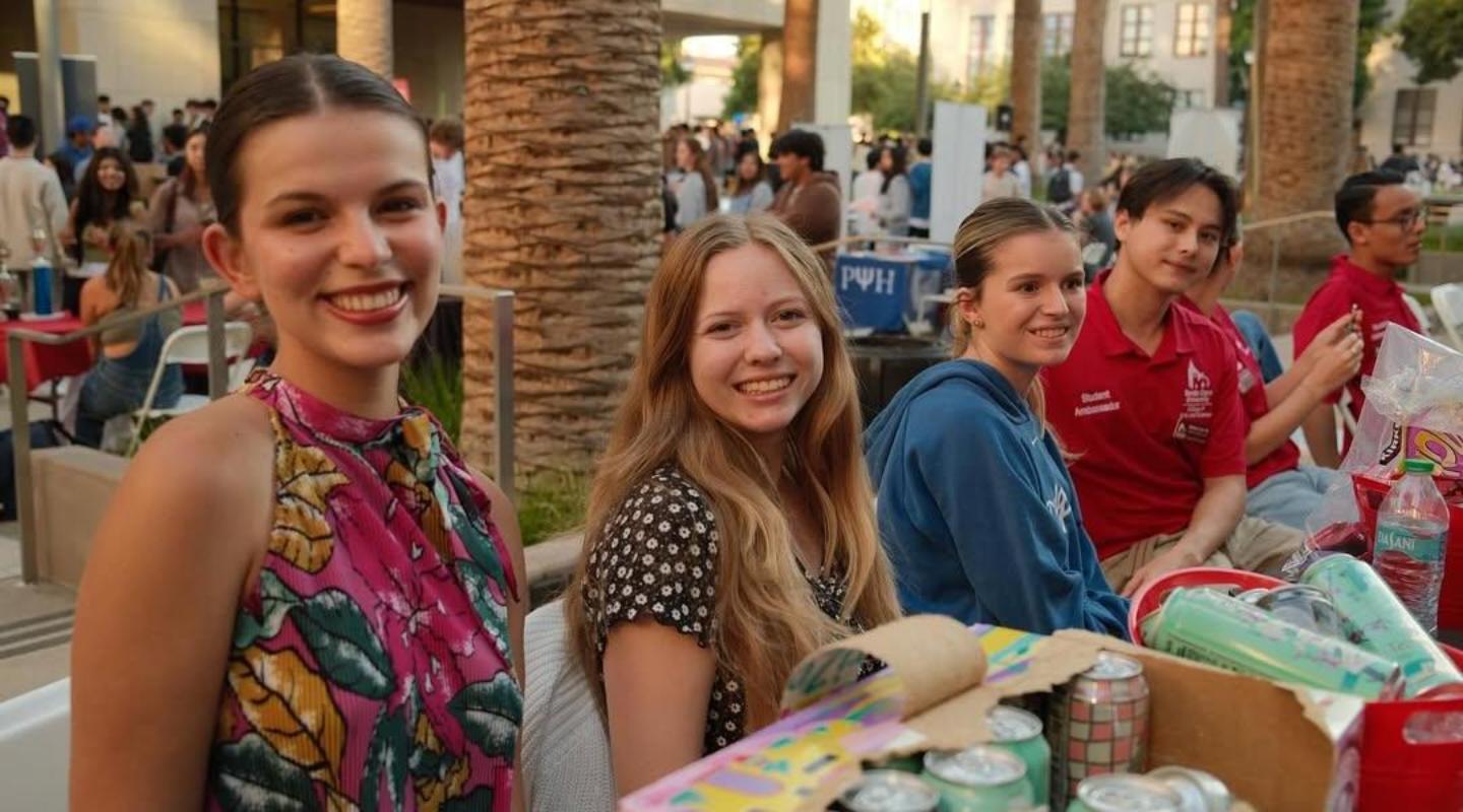 Students sitting behind a table at a club fair 