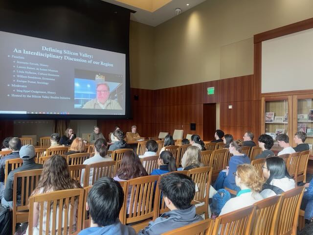 Guests in the SCU Librarys St. Clare room listen to a panelist via Zoom