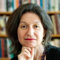 A person posing in front of a bookshelf. image link to story