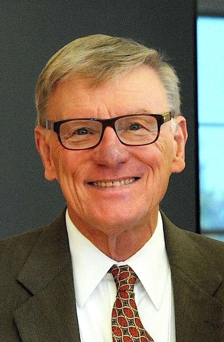 A smiling man wearing a suit and tie.