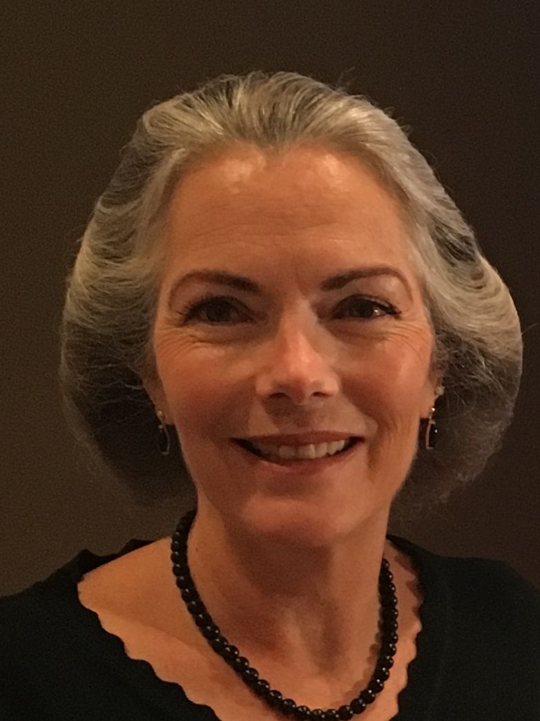 A smiling woman with short hair in a dark background. image link to story