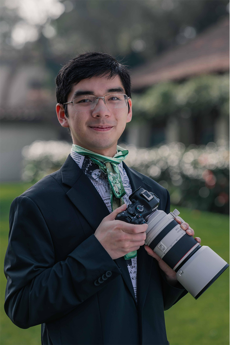 Dylan Ryu holding his large lens. camera