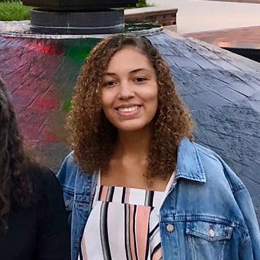 A person dressed casually sitting outside near a reflective pool. image link to story