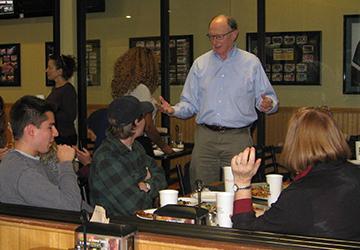 A group of people having pizza with a professor. image link to story