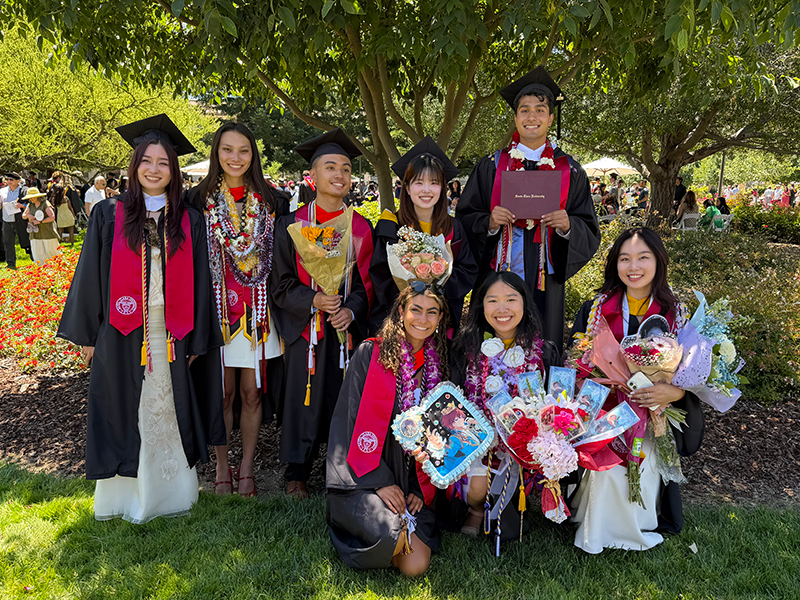 2026 graduates gathered under a tree 