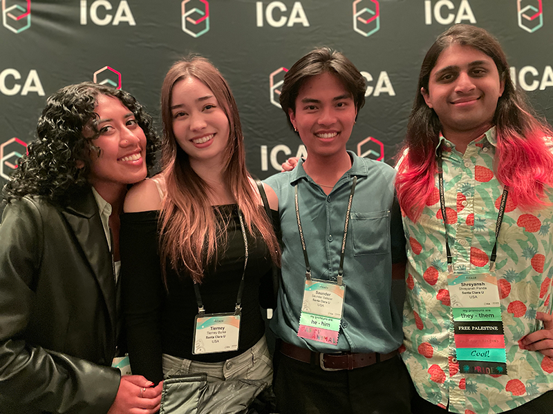 Four students in front of an ICA background