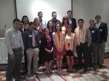A group of people posing for a photo in front of a screen.