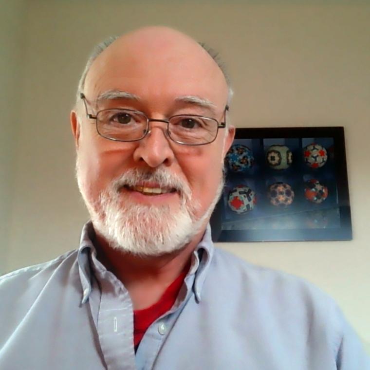 Headshot of a man named Frank Farris, smiling and wearing glasses.