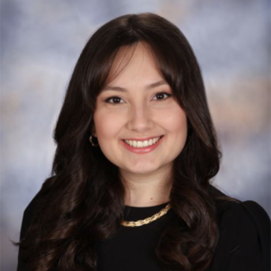 A woman in a black top smiling against a blurred background. image link to story