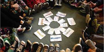 Feet poking into circle with cards in the center of the circle