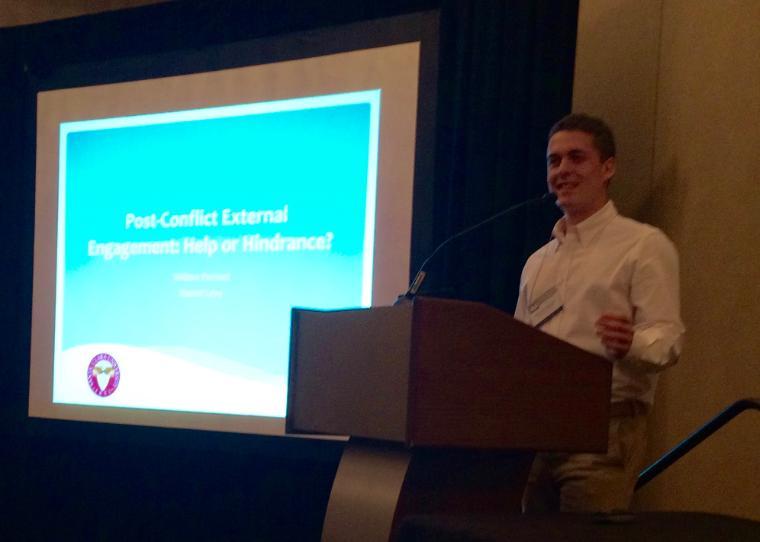 Will Portnof giving a presentation at a podium with a projected screen. image link to story
