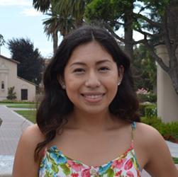 Woman standing in front of a historic building and fountain with palm trees. image link to story