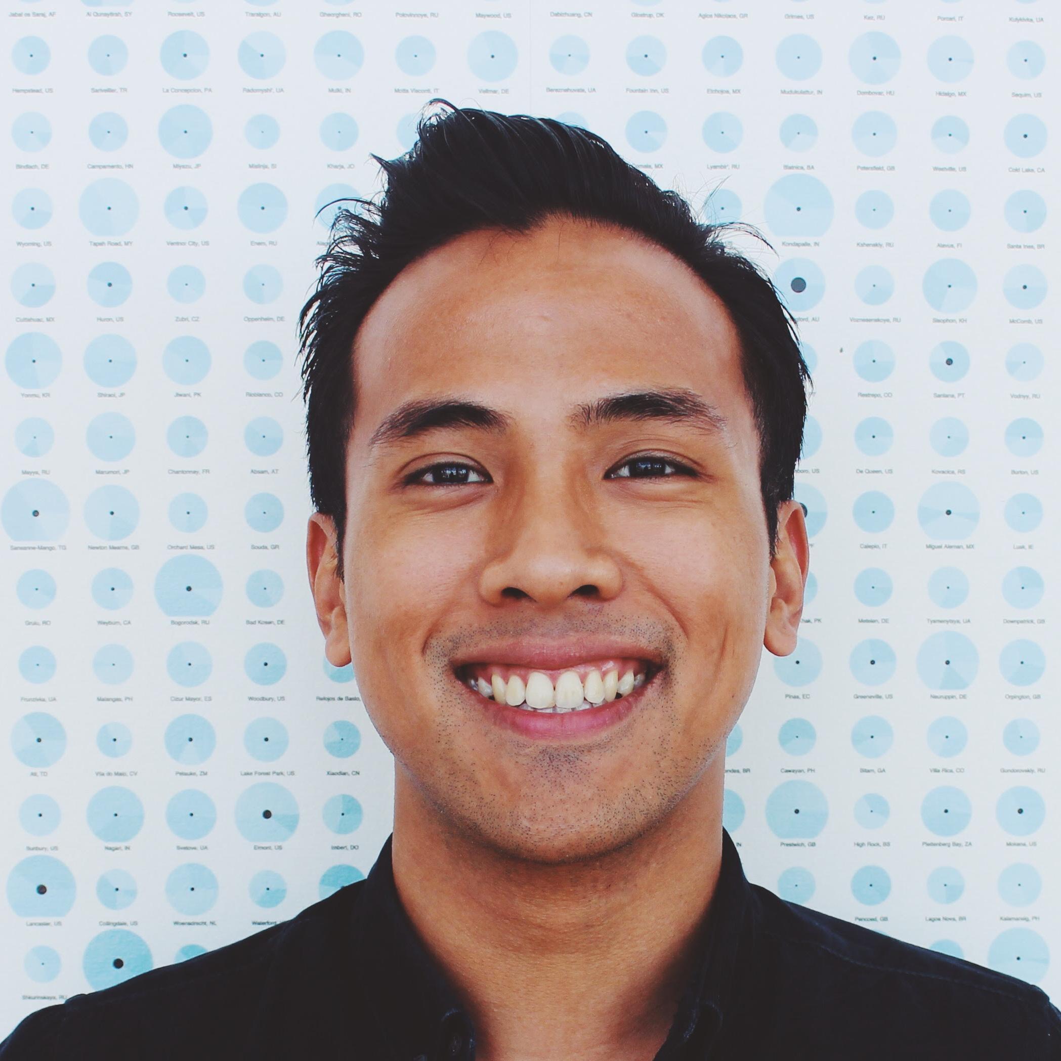 A person smiling in front of a tiled wall background. image link to story