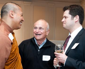 Three people conversing and laughing at an event.