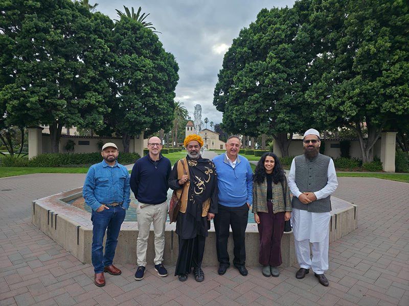 Religious studies faculty, friends and Sheikh Sahibzada Asim Maharvi next to the Abby Sobrato foundtain with Mission Santa Clara in the background.