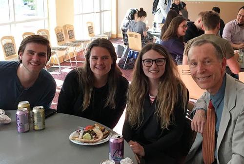 Four people smiling at a table during Aimes Spring Banquet.