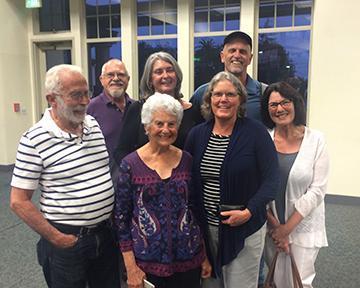 A group of people gathered indoors, smiling at the camera. image link to story