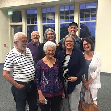 A group of people gathered indoors, smiling at the camera. image link to story