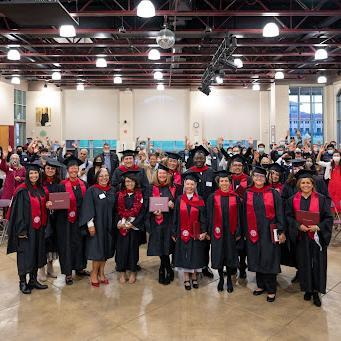all the grads lined up for picture with audience waving in back
