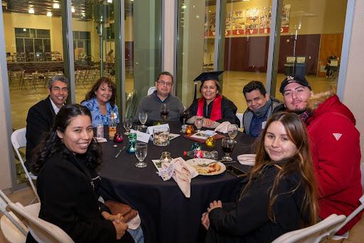 grads and parents posing for photo from table