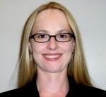 A person with glasses, smiling in front of a plain background. image link to story