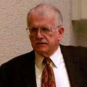 A man in a suit and tie speaking. image link to story