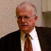 A man in a suit and tie speaking.