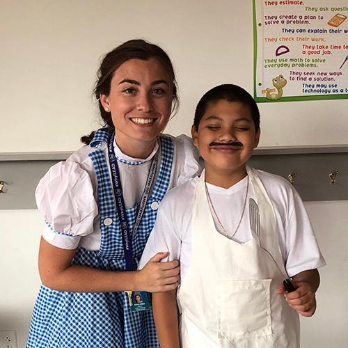 Two people in costume smiling indoors, 'Georgie Garner' to the left. image link to story
