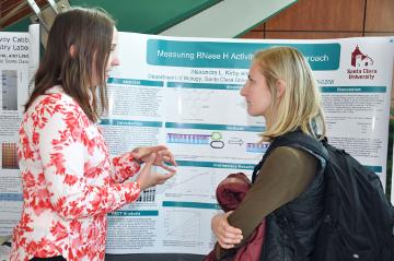 Two people discussing a research poster presentation.