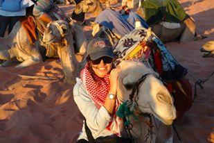 A person sitting on a camel with others in Wadi Rum, Jordan.