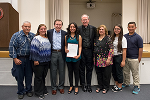 A group of people posing, one holding a certificate.