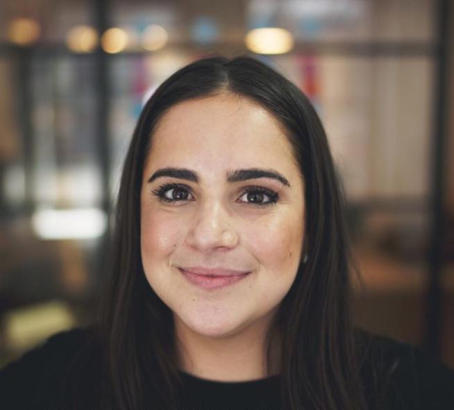 A person smiling with a blurred background. image link to story