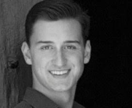 A person smiling in a black-and-white photo. image link to story