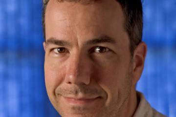 A person in front of a blue background.