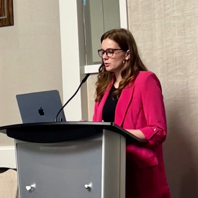 Sophie Copple at the podium presenting her work.