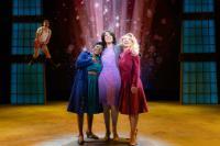 3 women with their arms around each other in a spotlight in a scene from 9 to 5