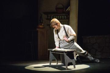 The Cripple of Inishmaan leaning over a table