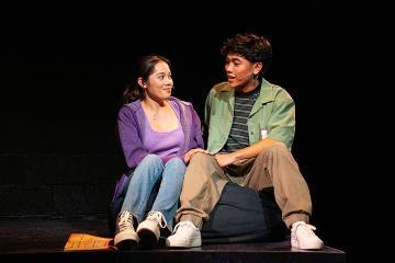 A male and female student in conversation seated next to each other