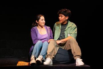 A male and female student in conversation seated next to each other